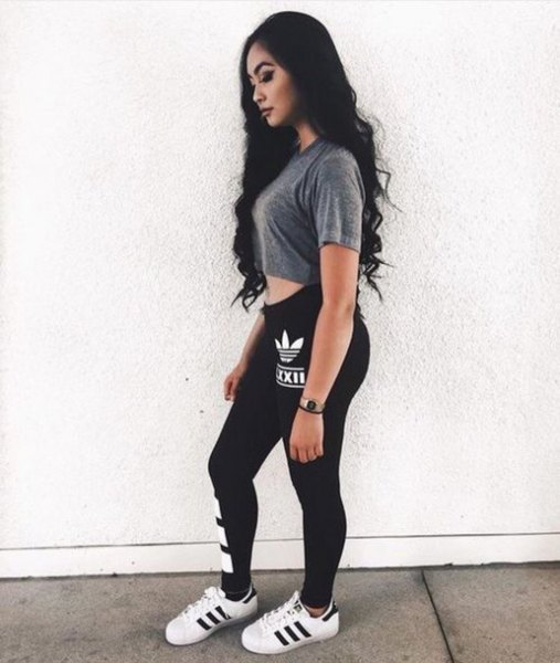 gray short t-shirt with black adidas leggings and white sneakers