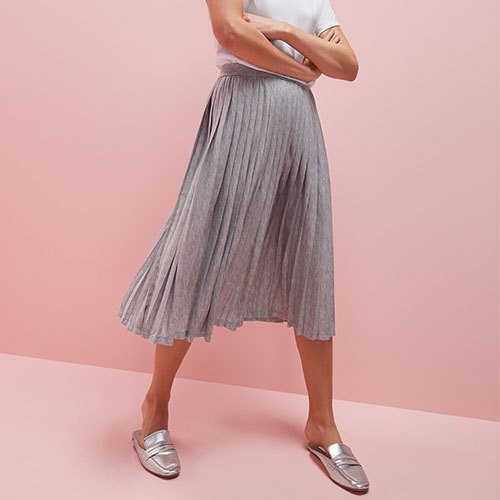 white t-shirt with light gray pleated skirt and silver evening shoes
