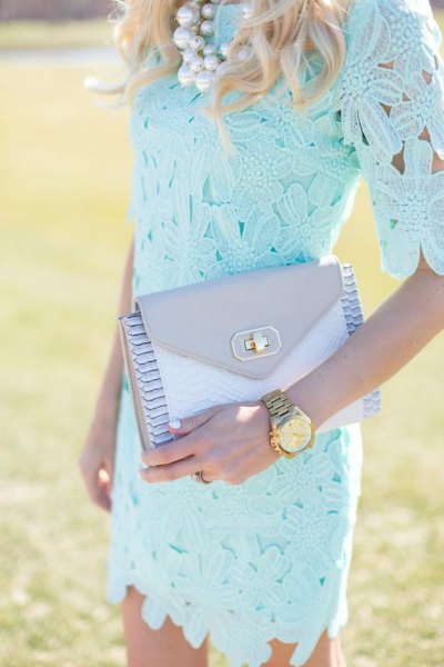 Light blue, form-fitting lace dress with half sleeves and a matching clutch