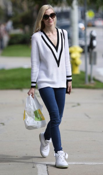 white and black rib sweater with V-neck and dark blue skinny jeans
