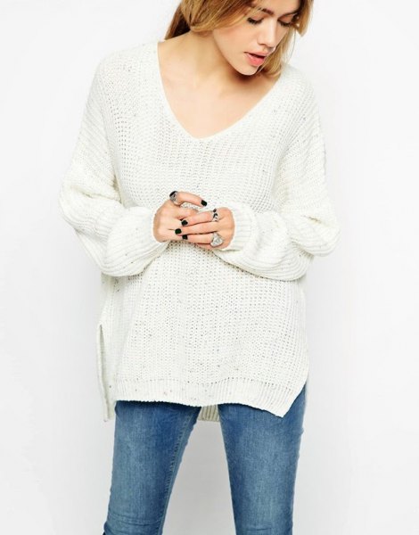 Side slit white sweater with blue skinny jeans