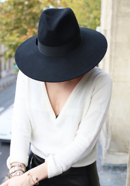 black felt hat with white v-neck sweater and skinny jeans