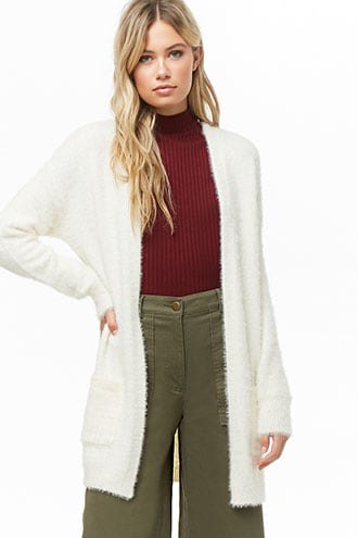 white, flaky long cardigan with green, ribbed sweater with mock-neck and trousers with wide legs