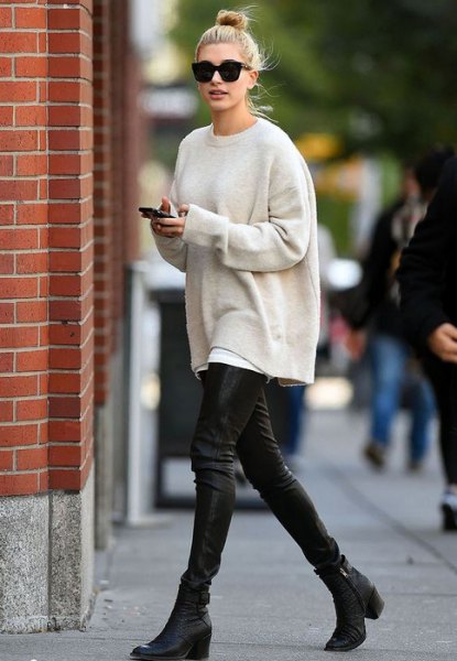 cream-colored oversized knit sweater with black leather gaiters