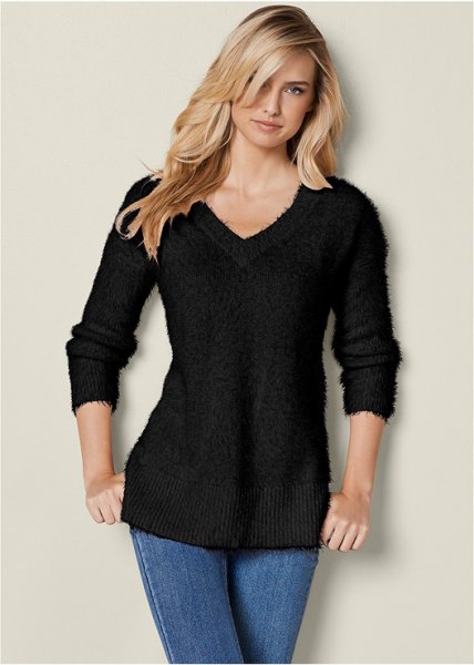 black slim fit knit sweater with V-neck and blue skinny jeans