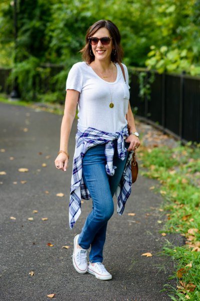white V-neck t-shirt, jeans and blue checked shirt tied around the waist