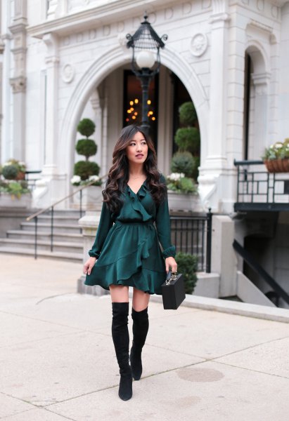 black V-neck blouse with ruffles, matching skater skirt and flat over the knee boots