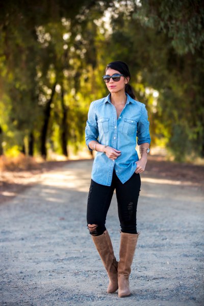 Light blue chambray shirt with buttons, black jeans and flat, knee high boots made of gray suede