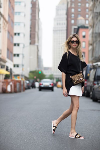 black oversized t-shirt with white mini skirt and gold slippers