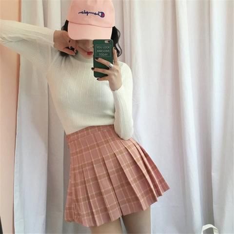 white figure-hugging sweater with pink checkered skirt and white baseball cap