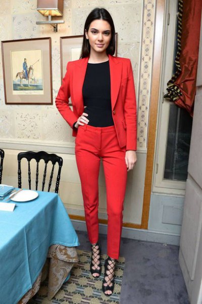 black crew-neck t-shirt, red suit and strappy heels with open toes