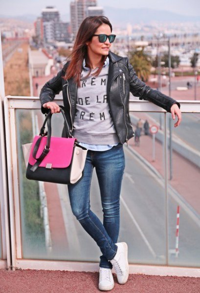 black leather jacket with gray graphic sweater and white tennis shoes