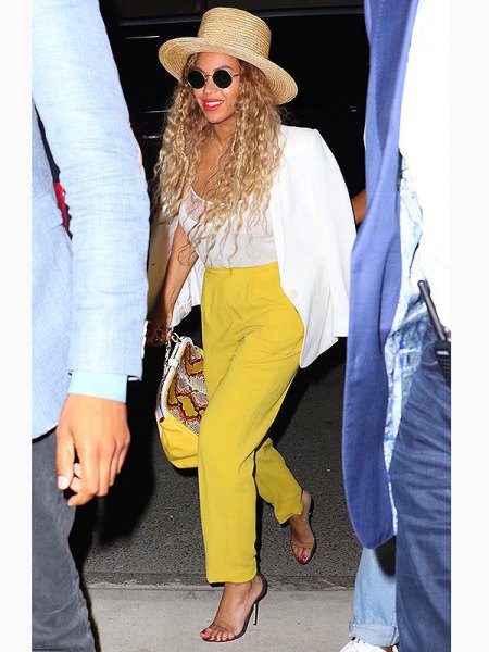 white blazer with mustard yellow trousers with straight legs and straw hat