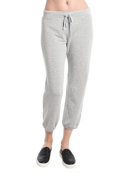 white crop top with light gray fleece pants and low trainers