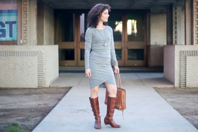 gray, long-sleeved, form-fitting bandage dress with knee-high boots made of brown leather with side zip