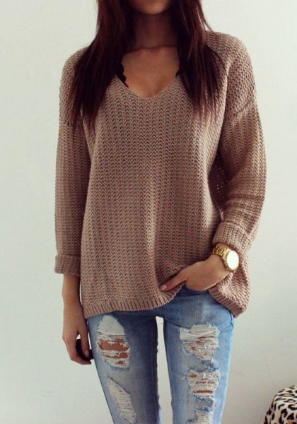 gray knitted sweater with V-neck and relaxed fit with torn boyfriend jeans