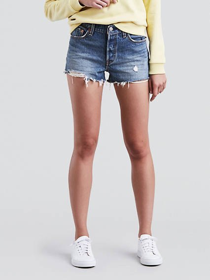 Light yellow, chunky sweatshirt with blue Levis denim shorts and white sneakers