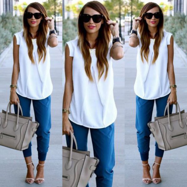 white sleeveless chiffon blouse with blue trousers with a conical leg