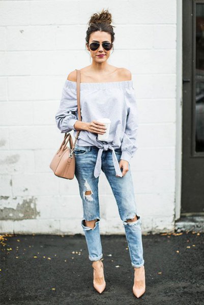 light blue knotted from the shoulder blouse with heavily torn jeans
