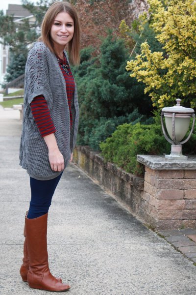 gray cardigan with wide sleeves and knee-high boots made of brown leather