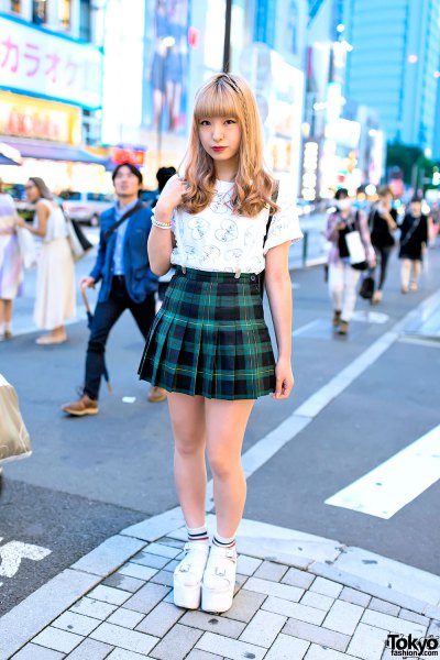 white graphic t-shirt with green and black checkered mini pleated skirt