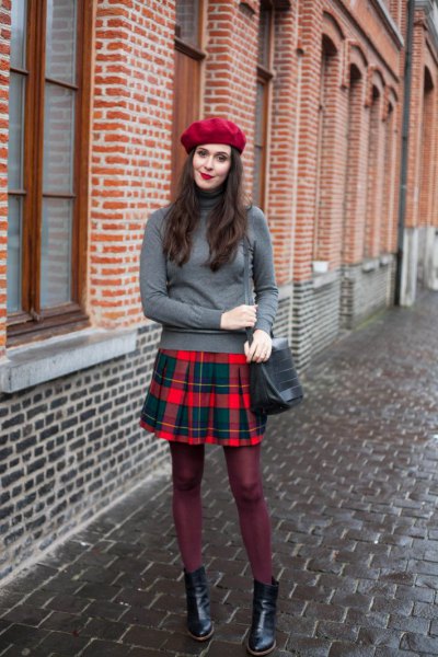 gray sweater with stand-up collar and red and blue checkered pleated skirt