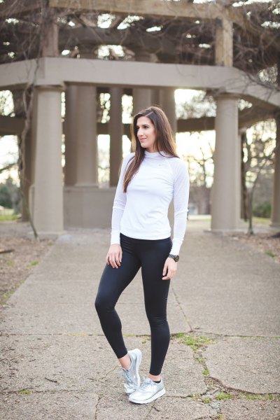 Light gray long-sleeved t-shirt with mock neck, black running trousers and silver sneakers