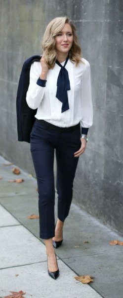 white with black tie neck and dark jeans