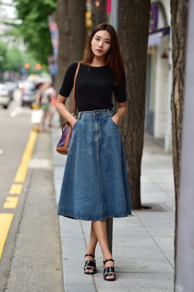black short-sleeved T-shirt with a long denim skirt and long sandals