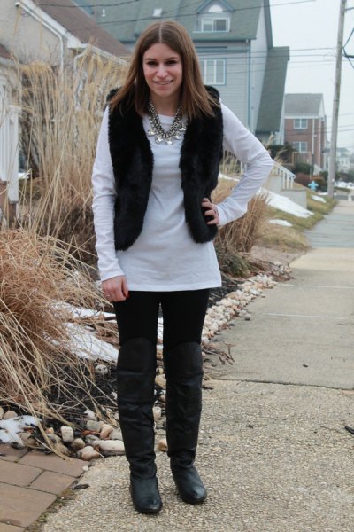 white long sleeve tunic top with black jeans and knee-high boots in leather