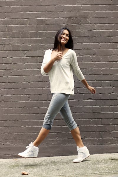 white bucket neck sweater with gray knee-length skinny jeans