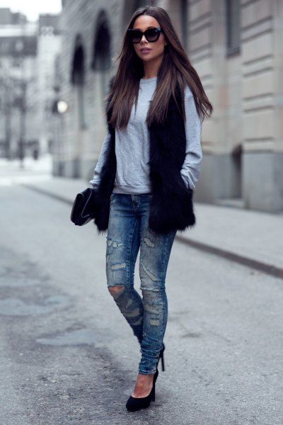 black fur vest with gray sweater and ripped slim fit jeans