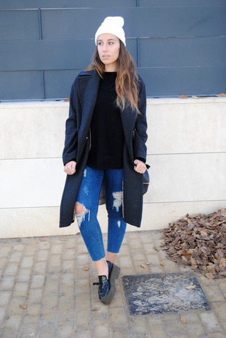 black wool coat with blue ripped slim fit jeans and leather platforms