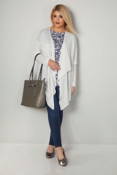 white longline cardigan with stem printed top and navy trousers