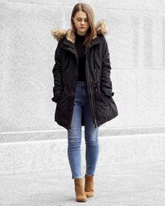 black cotton jacket with long fur in fur coat with slim ankle blue jeans