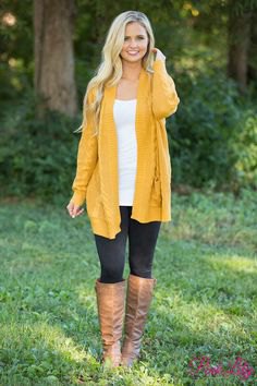 mustard yellow long-line sweater jacket with brown knee-high leather shoes
