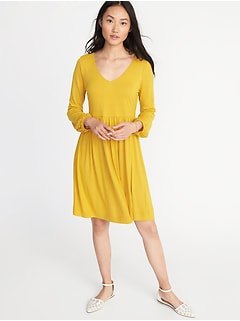 mustard yellow v-neck fit and flared knee-length dress with white flats
