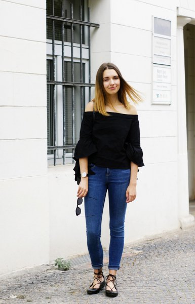 black of shoulder-warm blouse with blue skinny cuffed jeans