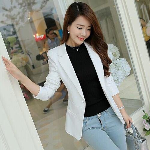 white blazer with black crew neck sweater and light blue jeans