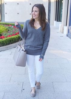 gray v-neck sweater with white slim fit jeans