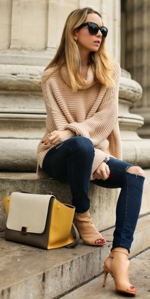 light pink large knit sweater with ripped dark jeans