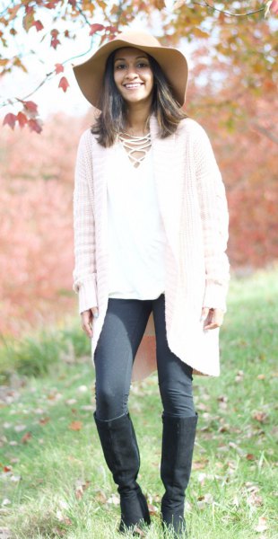 white knit cardigan with gray leggings and knee-high boots