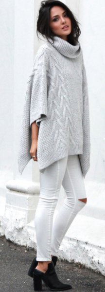gray turtleneck cable knit poncho sweater with white ripped skinny jeans