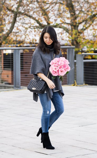gray half-heated poncho shirt with blue jeans and black boots