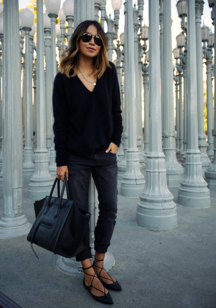black v-neck, chunky sweater with slim fit jeans and striped velvet positions