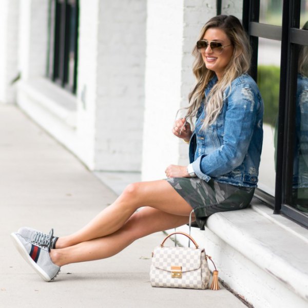 denim jacket with camo mini-shorts and light gray chambray sneakers