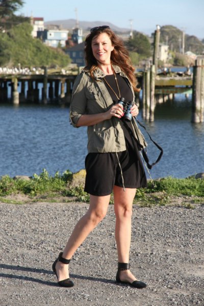 green windbreaker with black mini dress and ballet positions in the ankle