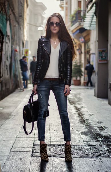 black moto jacket with white chiffon v-neck blouse and leopard print boots