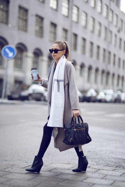 light gray long-line wool coat with white long scarf and black ankle boots