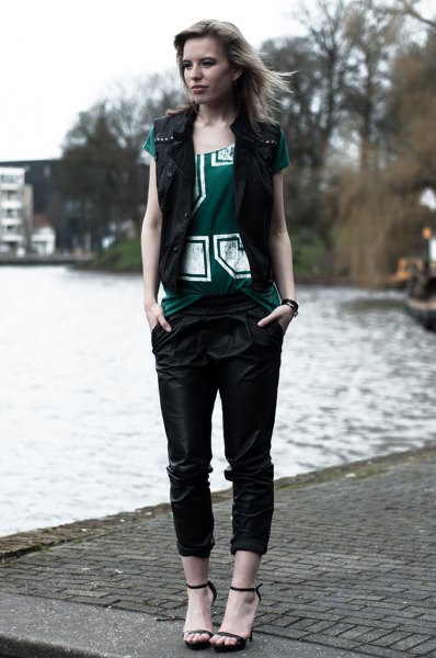 black vest with gray printed tee and leather pants